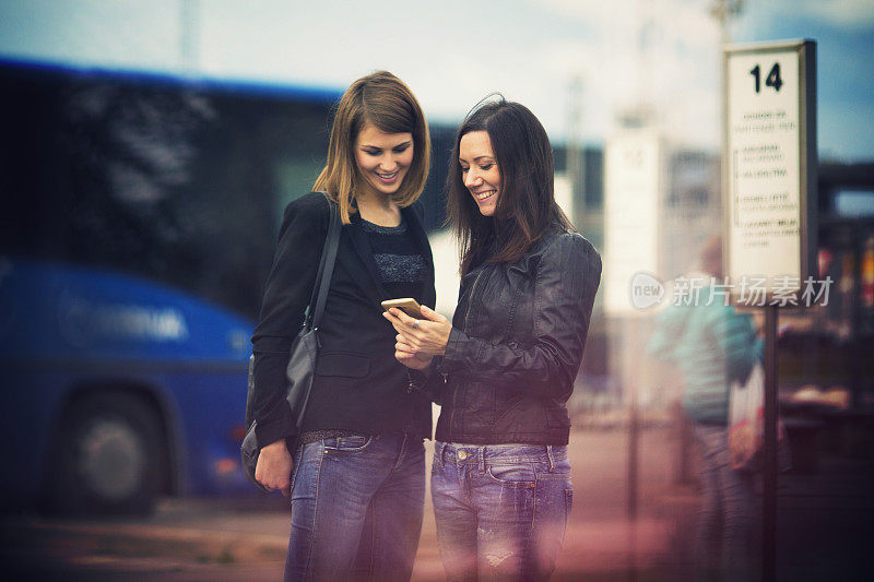 Young women waiting on the bus station